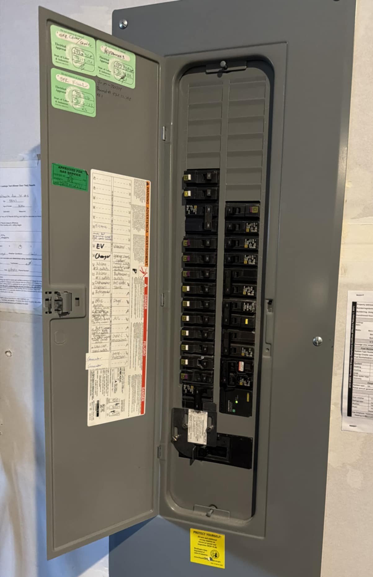 Le Bros Construction technician installing a 200-amp electrical panel upgrade in a Seattle-area home