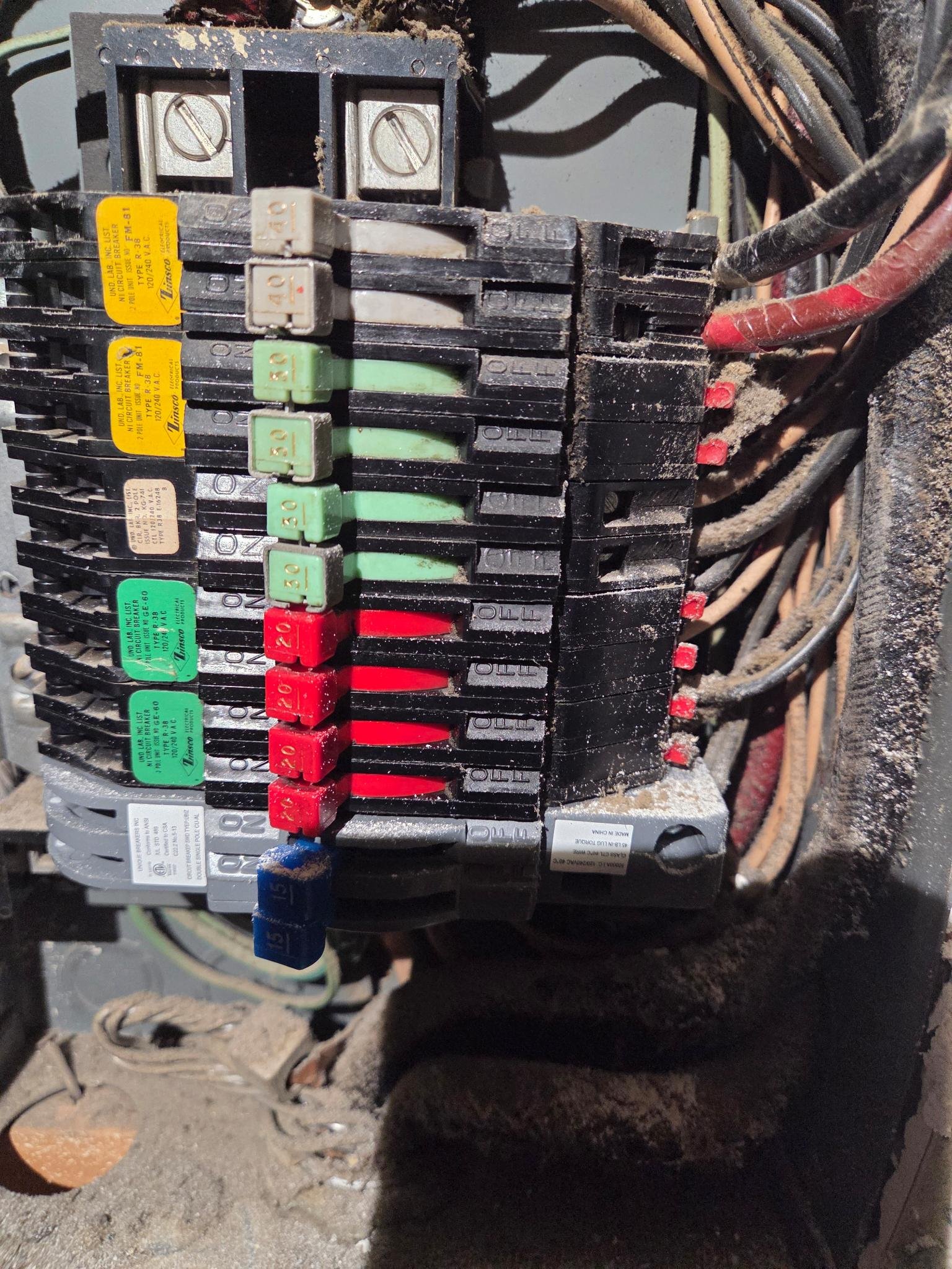 Before apartment panel swap by Le Bros Construction — original Trinsco-style box with 1980s breakers, decades of dust, and exposed wiring