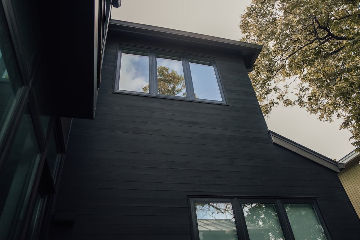 Black modern fiber cement DADU exterior with large windows — contemporary Seattle backyard cottage