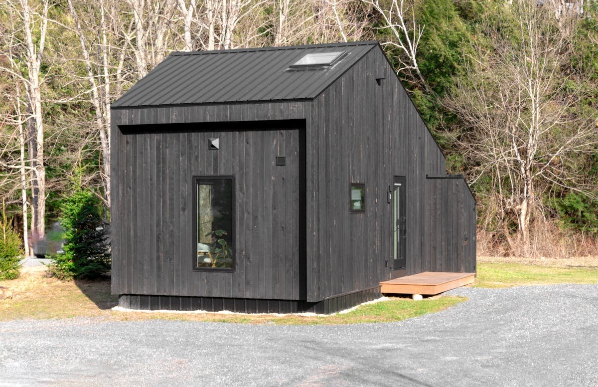 Dark cedar barn-style DADU — typical Pacific Northwest detached backyard cottage in Seattle area